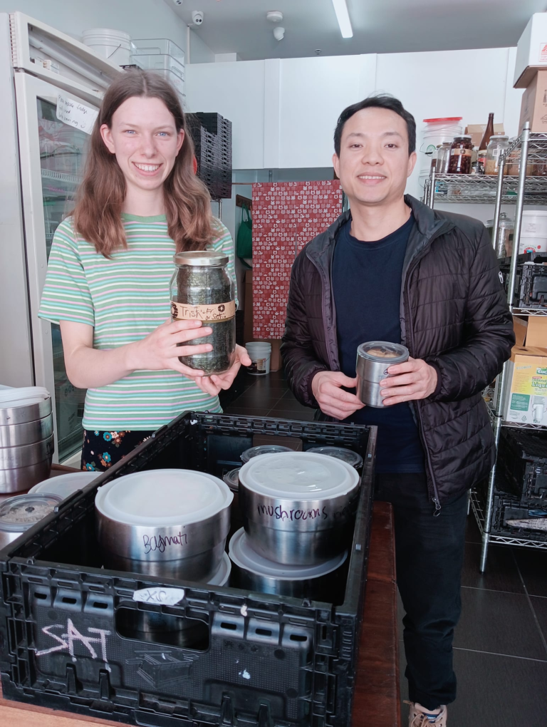 Wholefoods Unwrapped Collective staff member Annie with a student food relief customer and a selection of zero waste delicacies in Brunswick